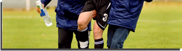 Soccer player being helped off the field due to a hamstring injury