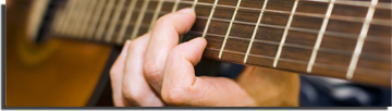 Close up of hands playing a guitar